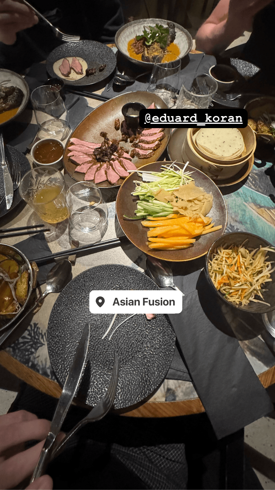 Shared plates of duck, vegetables, and salad at Asian Fusion restaurant